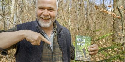 Janner mit Buch im Wald