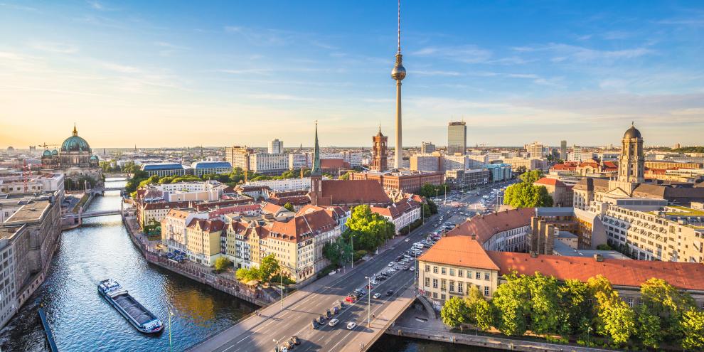 Berlin von oben. Zu sehen sind die Spree, der Fernsehturm, ein Schiff und viele Häuser.