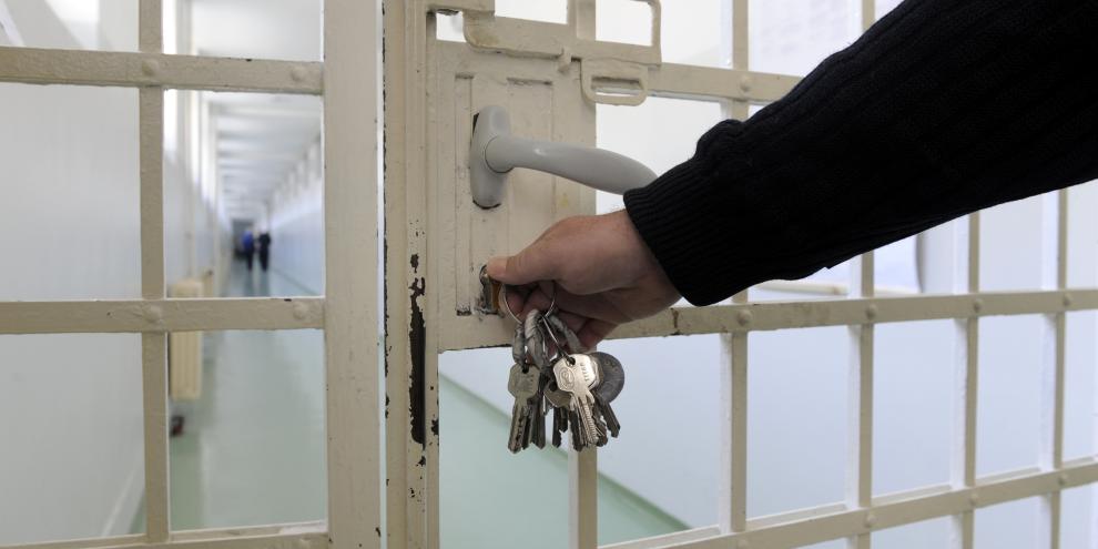 Beamter einer Justizvollzugsanstalt schließt Tür auf