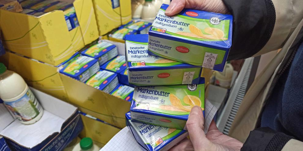 Eine Kundin hält Butterpäckchen bei Lidl in der Hand.