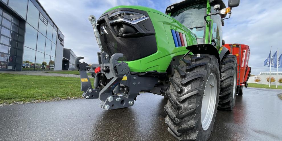 Elektrisch angetriebener Traktor der Marke Xeevo steht vor einer Verkaufshalle.