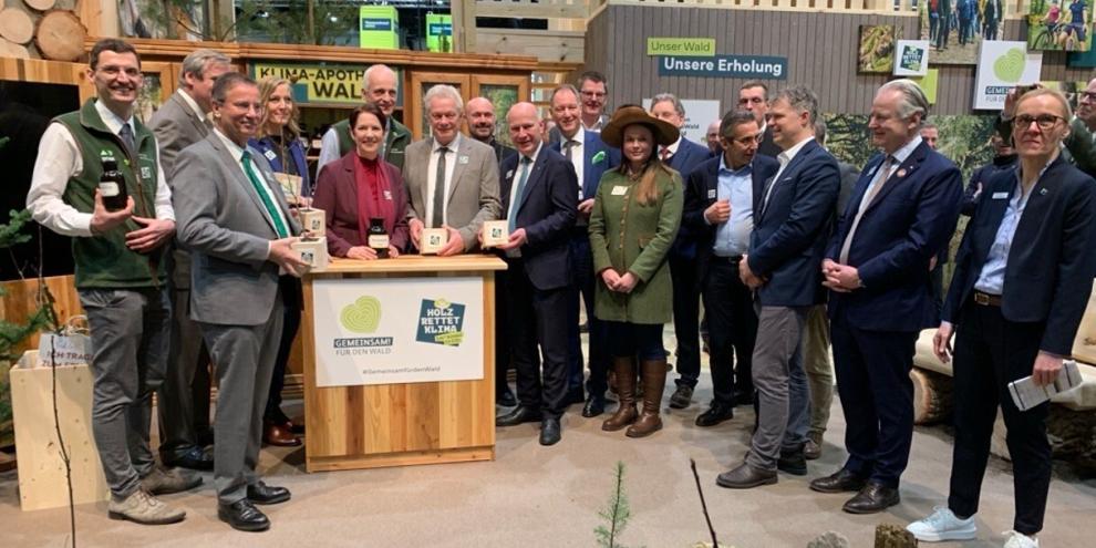 Am Pult mit Geschenk v. li. n. re.: Baden-Württembergs Forstminister Peter Hauk, Nordrhein-Westfalens Landwirtschaftsministerin Silke Gorißen, Bundeslandwirtschaftsminister Alois Rainer und Berlins Bürgermeister Kai Wegner besuchten am Eröffnungstag den Stand des DFWR.