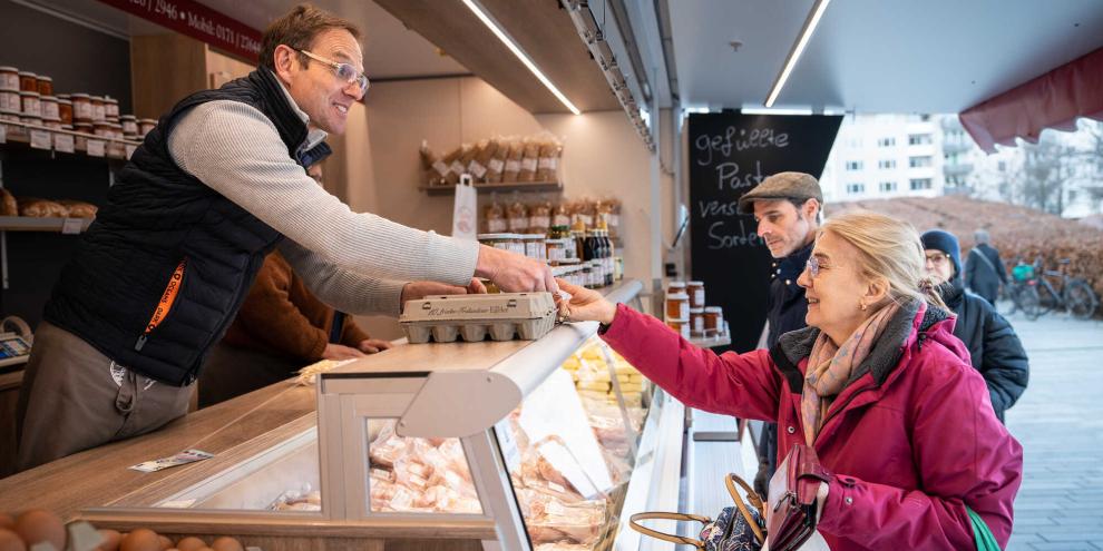 Das direkte Gespräch zwischen Erzeugern und Kunden an einem verkaufswagen auf dem Markt. 