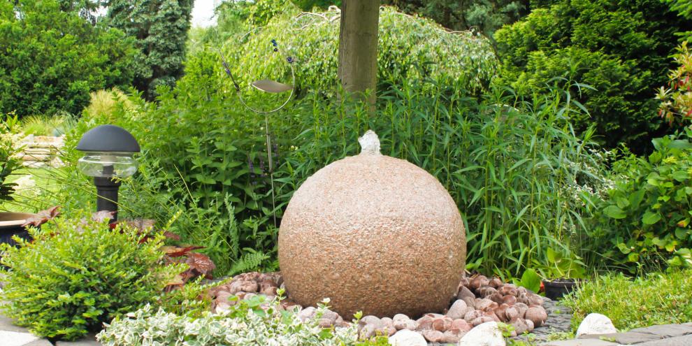 Ein kugeliger Quellstein bereichert kantige Ecken mit beruhigenden Plätschern.