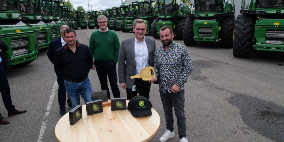 Mit dem „goldenen Schlüssel“ und 20 neuen Feldhäckslern beginnt für Köhl Harvest nun das nächste Kapitel in der Erntetechnik. Bei der Übergabe (v. l.) Denny Amato (Köhl Harvest), Ingo Köchling (JD), Daniel Metz (JD, Werksleiter Zweibrücken), Nick Köhl (Köhl Harvest).