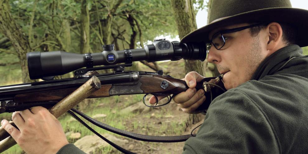 Die Waffe im Anschlag und den Locker im Mund erwartet den Jäger den heimlichen Brunftbock.