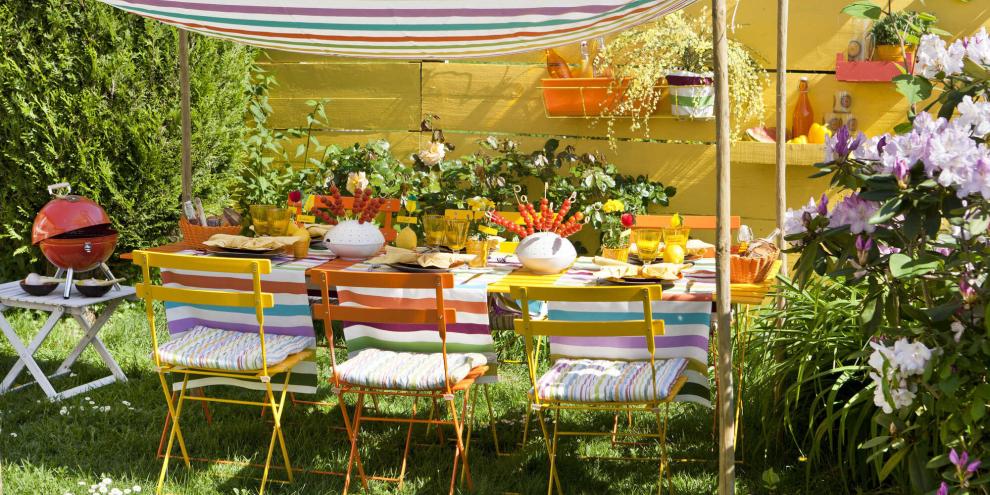 Bunt gestreiftes Tuch zwischen dünnen Holzstangen – fertig ist die einladende Schönwetter-Tafel.