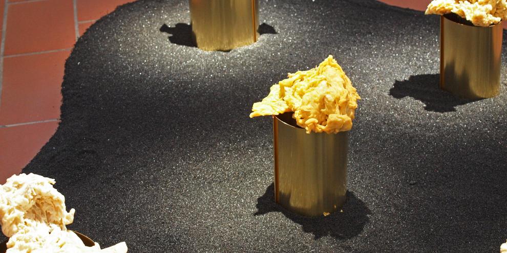 Stephanie Lünigs Installation mit Wachs über Stelen auf schwarzem Quarzsand in der Ulmer Ausstellung „Honig für Kunst & Gesellschaft“.