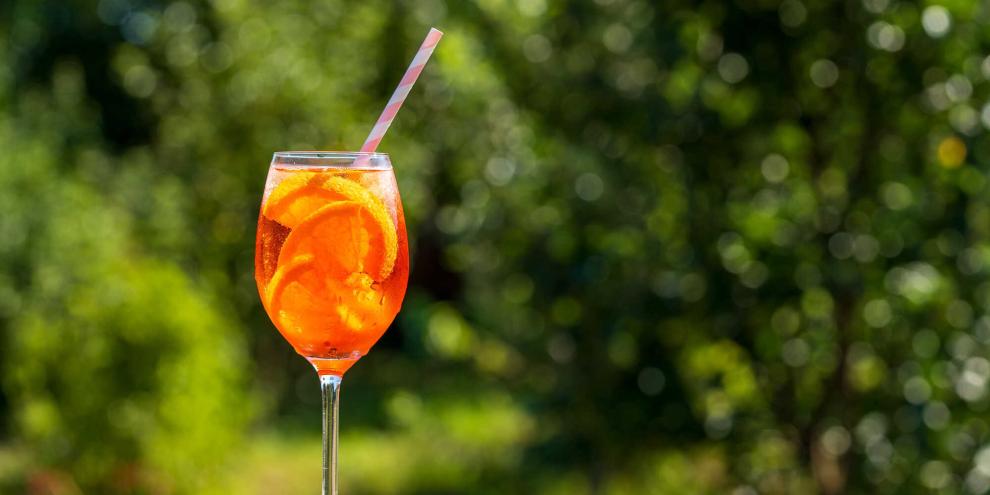 Orange im Glas, Eiswürfel und ein Platz in der Sonne: Aperol Spritz steht für unbeschwerten Genuss. Doch ganz so leicht ist seine Geschichte nicht.