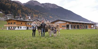 Familie Rasinger vor ihrem Aussiedlerhof am Ortsrand von Fulpmes im Stubaital: Patrizia Rasinger mit Tochter Gloria, Lukas Rasinger und die Buben Andre und Xander präsentieren stolz zwei ihrer starken Braunviehkühe: Europasiegerin Lennox Sabrina (l.) und IGBS-Reservechampion Phil Sissi.