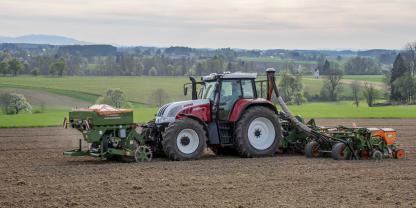 Eine Einzelkornsämaschine mit Fronttank im Frühjahr auf einem Acker. 