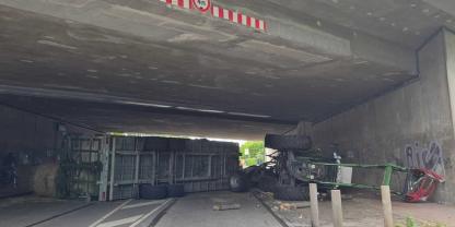 Ein umgekippter Traktor unter einer Brücke