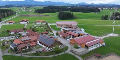 Ein Bauernhof mit Windrad und Solar