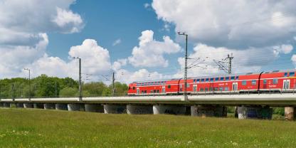 Eine Bahn fährt über eine Wiese