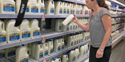 Eine Verbraucherin kauft in einem australischen Supermarkt Trinkmilch.