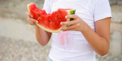 Bei einer saftigen Wassermelone passiert es schnell, dass ein paar Flecken auf der Kleidung landen.