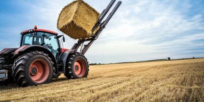 Ein Traktor mit Rundballen auf einem Feld