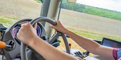 Eine Frau fährt Traktor auf dem Acker