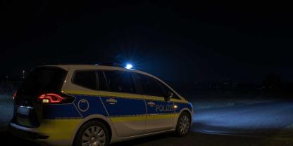 Ein Polizeiauto in der Nacht bei einer Kontrolle