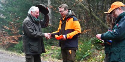 Staatssekretär Ruhl bei der Bruchübergabe nach der erfolgreichen Drückjagd.