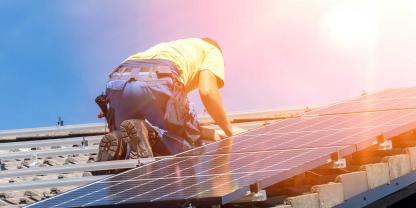 Handwerker installiert eine Photovoltaik-Anlage auf einem Dach (Symbolbild).