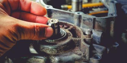 Ein Landmaschinenmechatroniker im Einsatz mit einem Getriebe