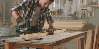 Landwirt arbeitet in Werkstatt mit Stauchkopfnagler von Makita. (Symbolbild mit KI erzeugt)