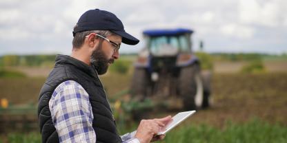 Landwirt mit Tablet auf dem Acker