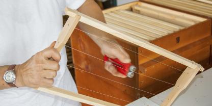 Indem man die Drähte durch einen Rillenrad-Drahtspanner zieht, verleiht man ihnen die notwendige Spannung.