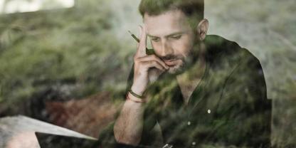 Ein Landwirt sitzt nachdenklich an einer Schreibarbeit.