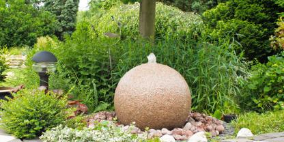 Ein kugeliger Quellstein bereichert kantige Ecken mit beruhigenden Plätschern.