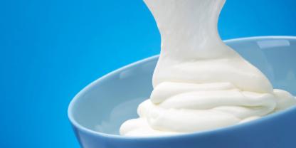 Griechischer Joghurt läuft in eine Schale.