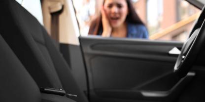 Eine Frau blickt erschreckt in ein Auto