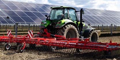 Ein Traktor in einer Agri-PV Anlage