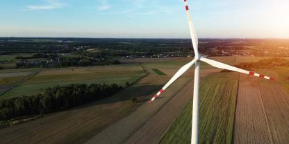 Ein Windrad über einer Agrarlandschaft