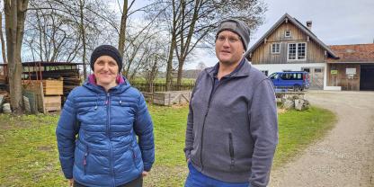 Ein Mann und eine Frau vor einem landwirtschaftlichen Gebäude