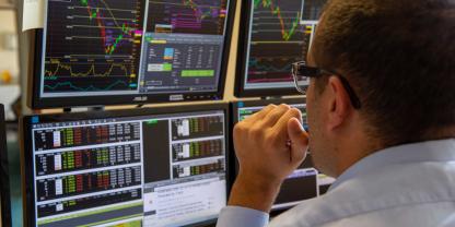 Ein Börsenhändler beobachtet mehrere Bildschirme