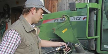 Ein Landwirt betankt seinen Traktor.