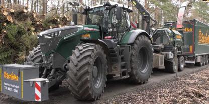 Ein Fendt Traktor beim Holzhacken im Wald