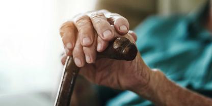 Die Hand eines alten Mannes mit Gehstock