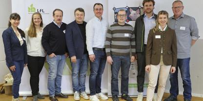 Menschen stehen vor einer Leinwand an der LfL.