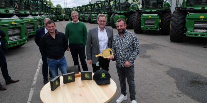 Mit dem „goldenen Schlüssel“ und 20 neuen Feldhäckslern beginnt für Köhl Harvest nun das nächste Kapitel in der Erntetechnik. Bei der Übergabe (v. l.) Denny Amato (Köhl Harvest), Ingo Köchling (JD), Daniel Metz (JD, Werksleiter Zweibrücken), Nick Köhl (Köhl Harvest).