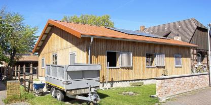 Ansicht der neuen Halle von der Straße aus: Die Holzkonstruktion bietet Platz für vier Pferdeboxen, Sattelkammer und Lagerraum. Sie fügt sich gut in die bestehnde Bebauung des Ortes ein.