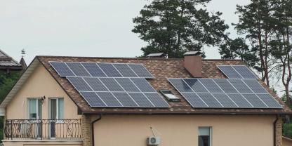 Nadelbäume neben einem Hausdach mit Solarmodulen (Schmuckbild): Was ist wichtiger, Bäume zu schützen oder Solaranlagen zu fördern?