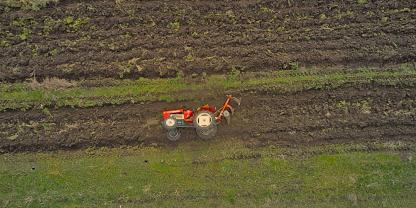 Ein Traktor liegt umgestürzt auf einem Feld