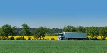 Ein Auflieger und Lkw neben einem Feld