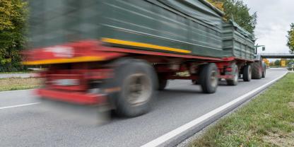 Ein Traktor mit Anhängern auf einer Straße