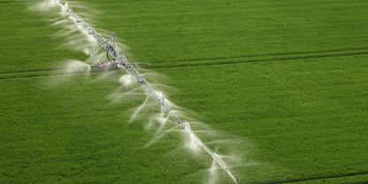 Luftbild: Ein Feld wird bewässert.