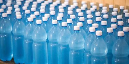 Wasserflaschen stehen aufgereiht auf einem Tisch