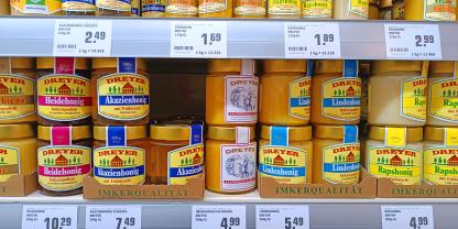 Honige mit D.I.B.-Etikett und von Abfüllern im Supermarktregal.